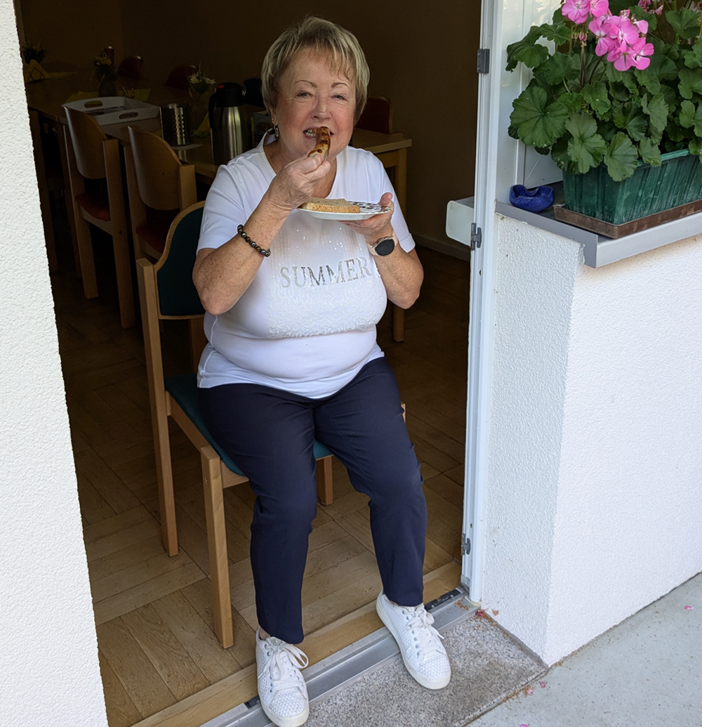 eine Frau isst eine Bratwurst und freut sich